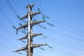 High-voltage power line grey metal prop with many wires vertical view over clear cloudless blue sky Royalty Free Stock Photo