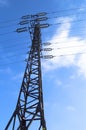 High-voltage power line 110 kV, metal support, wires, insulators, against the blue sky, vertical shot Royalty Free Stock Photo