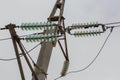 High voltage power line pole with glass electrical insulators on wires Royalty Free Stock Photo