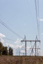 High voltage power line and pylons on a sunny day against the blue sky with clouds Royalty Free Stock Photo