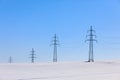 High voltage power lines against a blue sky