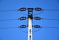 High voltage power lines and concrete electrical pole in low angle abstract view. Royalty Free Stock Photo