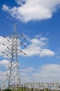 High voltage power lines with electricity pylons at blue sky. Royalty Free Stock Photo