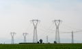 High voltage power lines on green meadows Royalty Free Stock Photo