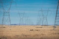 High voltage power lines in mountain desert against blue sky. Royalty Free Stock Photo