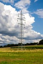 High voltage power lines and power lines in a flat and green landscape on a sunny day with clouds in the blue sky. Royalty Free Stock Photo