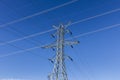 High-voltage power lines and pylon against blue sky II Royalty Free Stock Photo