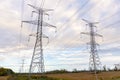 High voltage power lines supported by tall pylons in the countryside in autumn Royalty Free Stock Photo