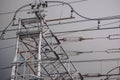 High voltage power lines and tower against a cloudy sky during day, showcasing electrical infrastructure and utility services Royalty Free Stock Photo
