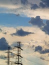 High voltage power lines under blue cloudy sky Royalty Free Stock Photo