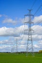 High-voltage power transmission line in a cereal field on a background of blue sky Royalty Free Stock Photo