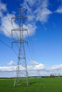 High-voltage power transmission line in a cereal field on a background of blue sky Royalty Free Stock Photo