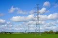 High-voltage power transmission line in a cereal field on a background of blue sky Royalty Free Stock Photo