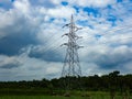 High voltage power transmission lines and tower with beautiful clouds in the background Royalty Free Stock Photo