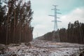 High-voltage powerlines and high-voltage pylons transporting electric power in a lane Royalty Free Stock Photo