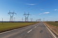 High voltage pylons with a cooling tower of a nuclear power plant view into a blue sky with clouds. Royalty Free Stock Photo