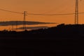 High voltage pylons located in the countryside at sunset