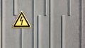 Danger yellow electricity sign on grey plastic background. Power, electricity warning sign Royalty Free Stock Photo