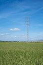 High voltage tower and cable line in the countryside under a blue sky Royalty Free Stock Photo