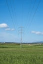 High voltage tower and cable line in the countryside under a blue sky Royalty Free Stock Photo