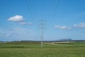 High voltage tower and cable line in the countryside under a blue sky Royalty Free Stock Photo