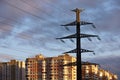 High voltage tower with electrical wires on background of residential buildings and evening sky Royalty Free Stock Photo