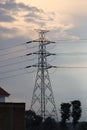 High Voltage Tower Stand Up Straight Around Houses In the Twilight