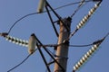 High-voltage towers against the blue sky. High-voltage electrical insulator. Electric hub on pole. Wires of high voltage in sky. Royalty Free Stock Photo