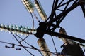 High-voltage towers against the blue sky. High-voltage electrical insulator. Electric hub on pole. Wires of high voltage in sky. Royalty Free Stock Photo