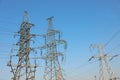 High voltage towers against blue sky on sunny day Royalty Free Stock Photo