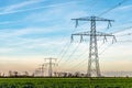 High voltage towers with thick hanging power cables in a rural l Royalty Free Stock Photo