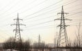 High-voltage towers, transmission line in winter city background. Royalty Free Stock Photo