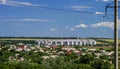 The high-voltage transmission line in the background of the village with grain-elevator complex for grain storage