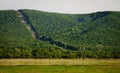 High voltage transmission line pass through the forest and mountain Royalty Free Stock Photo