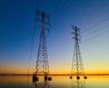 High voltage transmission lines crossing Wheeler Lake at dusk near Athens AL. Electricity pylons at sunset. Power and energy Royalty Free Stock Photo