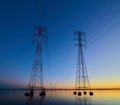 High voltage transmission lines crossing Wheeler Lake at dusk near Athens AL. Electricity pylons at sunset. Power and energy Royalty Free Stock Photo