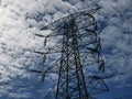 High voltage transmission tower against blue sky with clouds. Royalty Free Stock Photo