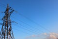 High voltage transmission tower line against blue sky, bottom view. iron construction. Royalty Free Stock Photo