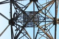 High voltage transmission tower line against blue sky, bottom view. iron construction. Royalty Free Stock Photo