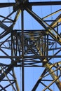 High voltage transmission tower line against blue sky, bottom view. iron construction. Royalty Free Stock Photo