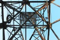 High voltage transmission tower line against blue sky, bottom view. iron construction. Royalty Free Stock Photo