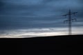 High-voltage transmission tower on the horizon at dusk