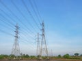 High voltage transmission towers with power line over blue sky and white cloud background Royalty Free Stock Photo