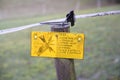 High voltage yellow danger sign farm field fence