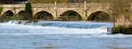 High water flow over Weir near Bath on the River Avon, carrying trees with it Royalty Free Stock Photo