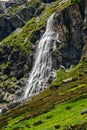 High waterfall and green hill in the mountains Royalty Free Stock Photo