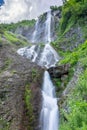 High waterfall with a powerful stream falling from a cliff