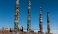 High wooden ritual pillars are tied with colorful ribbons.