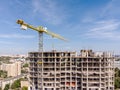 yellow crane near residential building under construction against blue sky Royalty Free Stock Photo