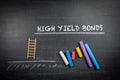 High yield bonds. Text and colored pieces of chalk on a dark board Royalty Free Stock Photo